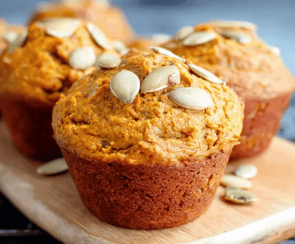 Delicious and healthy pumpkin muffins topped with cinnamon and walnuts, perfect for a nutritious breakfast or snack.