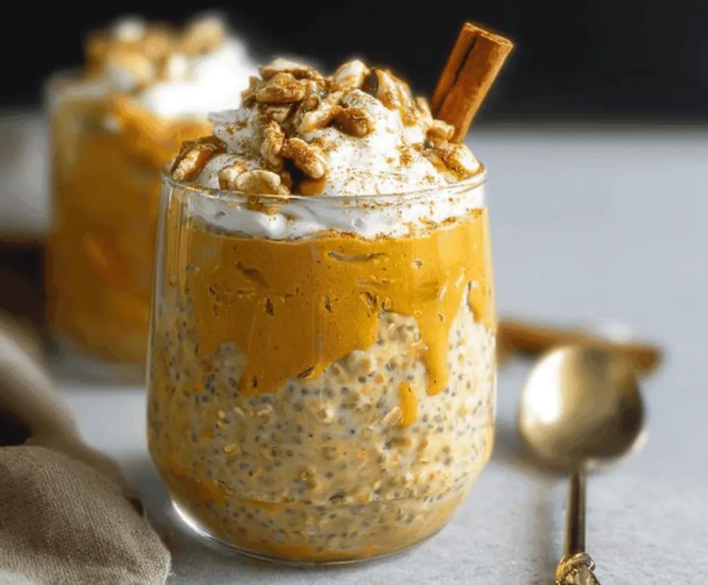 Creamy pumpkin pie overnight oats topped with whipped cream and cinnamon, perfect for a healthy breakfast in autumn.