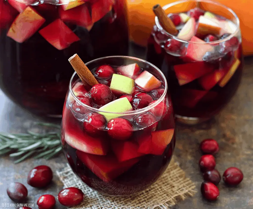 Refreshing Cranberry Apple Sangria in a glass with fresh cranberries, apple slices, and cinnamon sticks, perfect for a cozy fall party