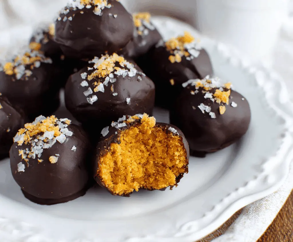Delicious homemade healthy pumpkin truffles with a creamy texture and festive fall flavors on a rustic wooden table