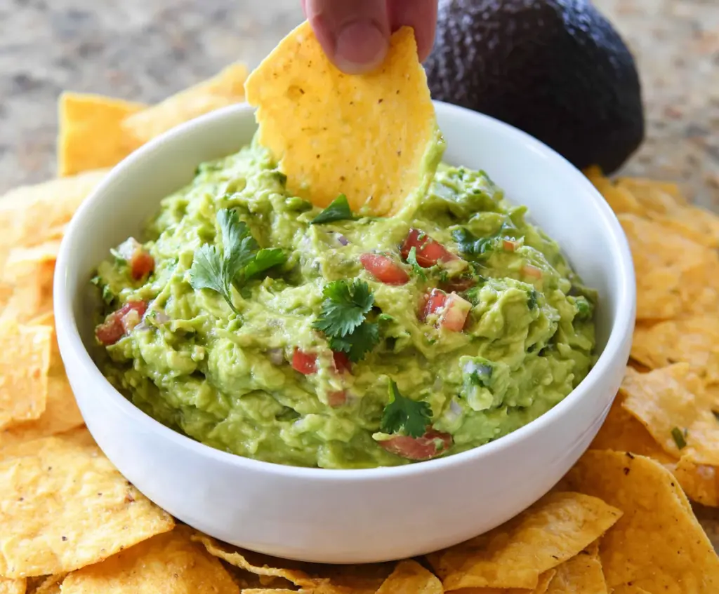 Creamy homemade guacamole made with ripe avocados, lime, cilantro, and onion, perfect for snacks and parties.